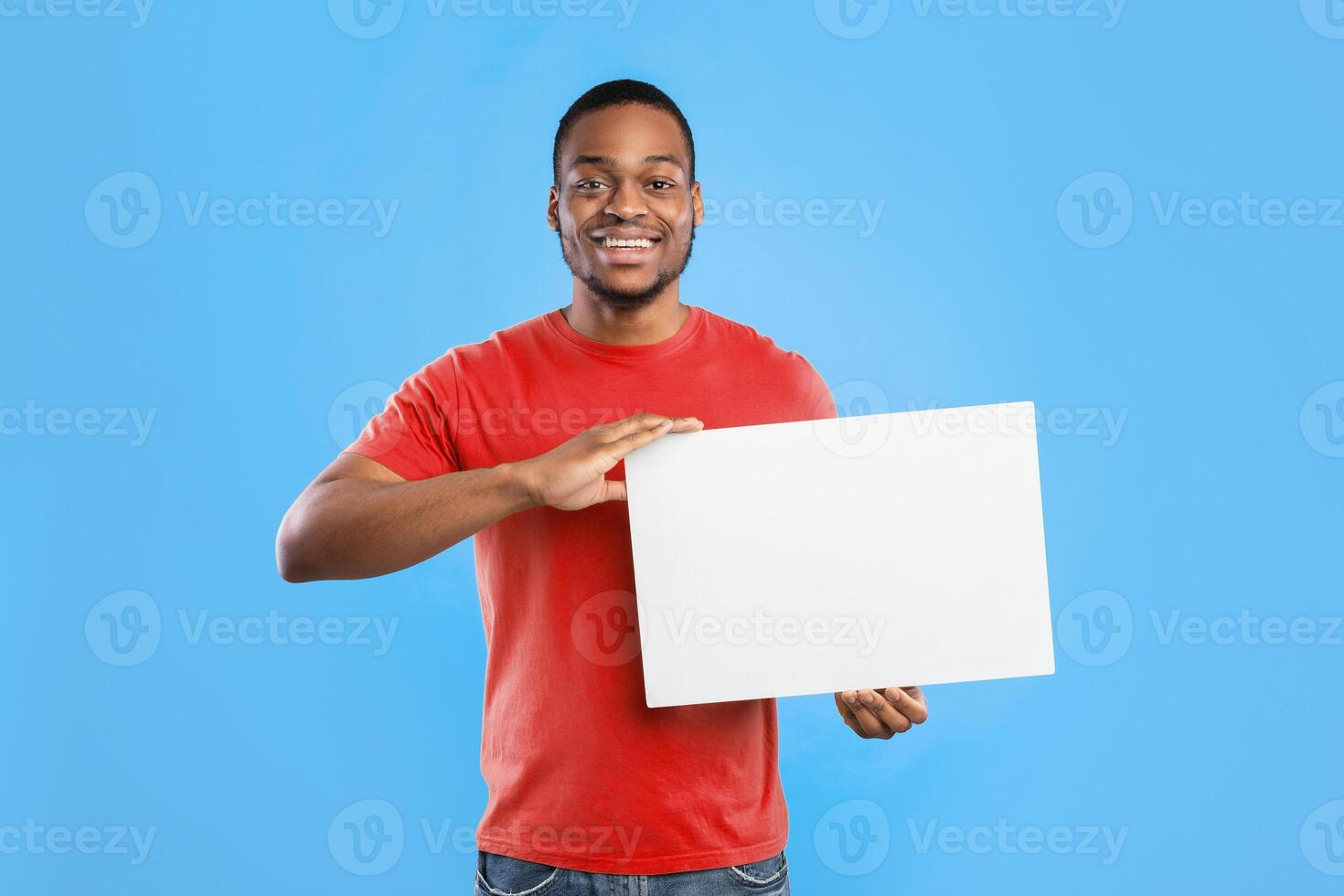 Great Offer. Black Young Man Showing Paper Poster With Blank Space For Text Advertisement Over Blue Studio Background. Guy Advertising Something Holding White Board Smiling To Camera. Mockup photo