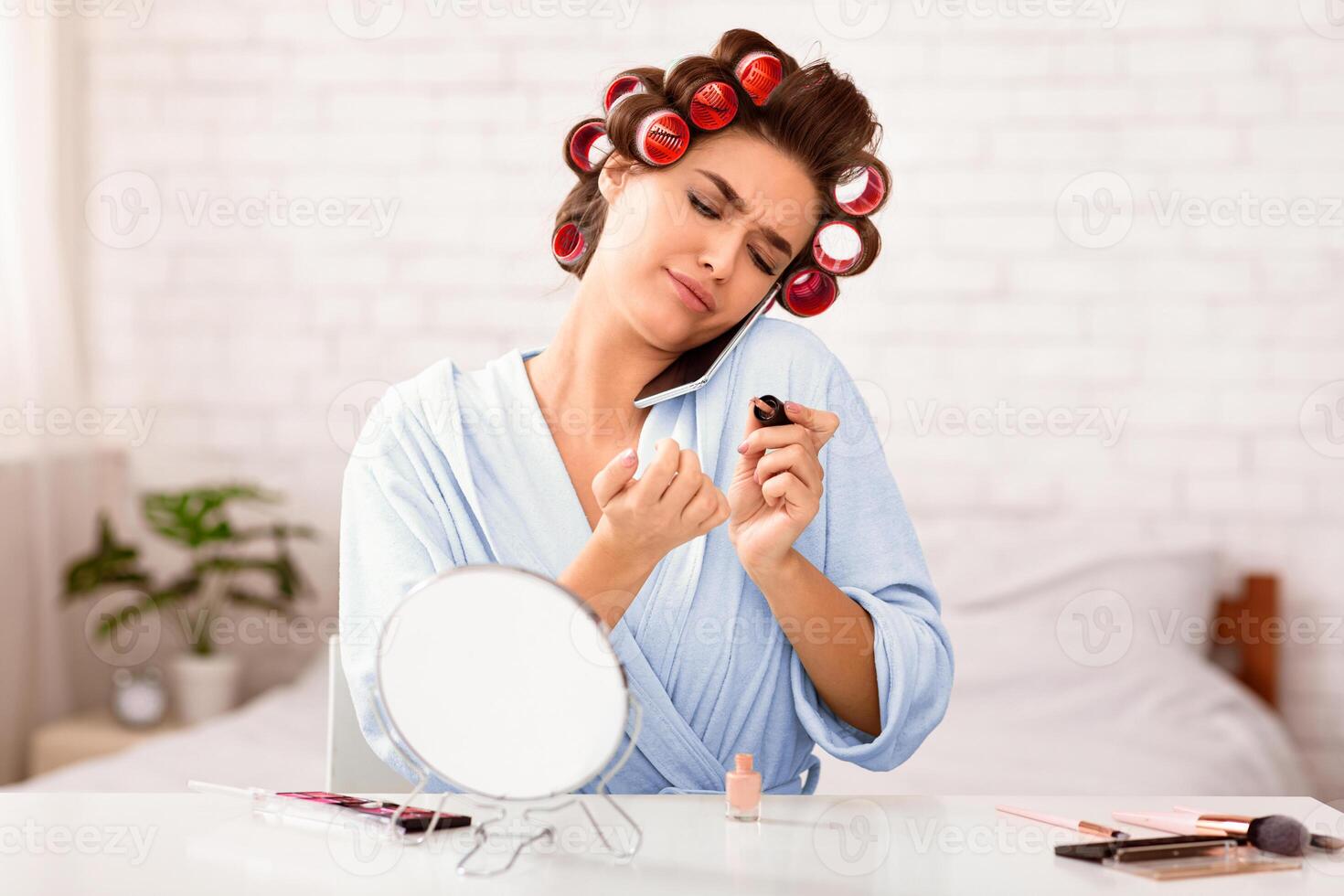 Discontented Housewife Talking On Cellphone Doing Nails Manicure Sitting At Home. Domestic Lifestyle. Selective Focus photo