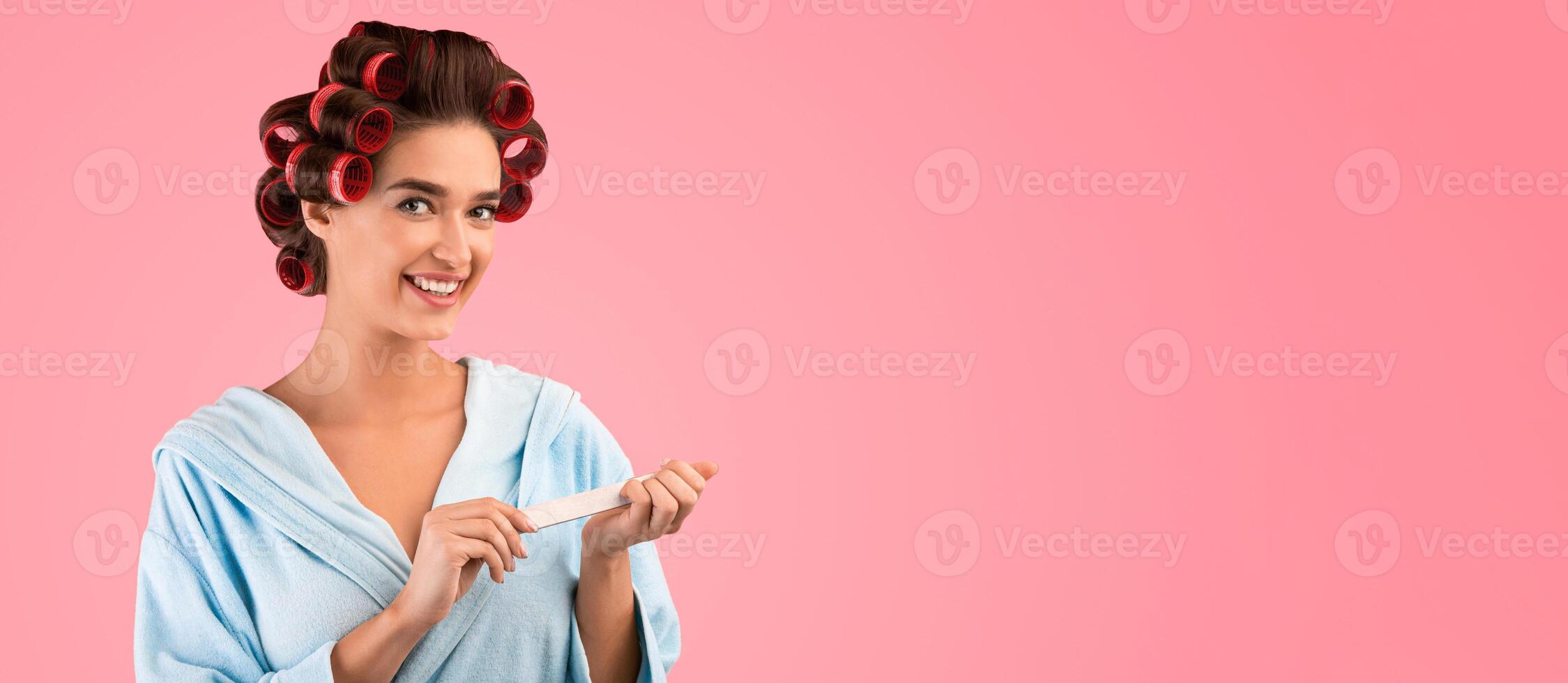 Cheerful Woman Doing Manicure Using Nail Buffer Caring For Fingernails Standing On Yellow Studio Background, Smiling To Camera. Female Beauty Routine And Nails Care Concept photo