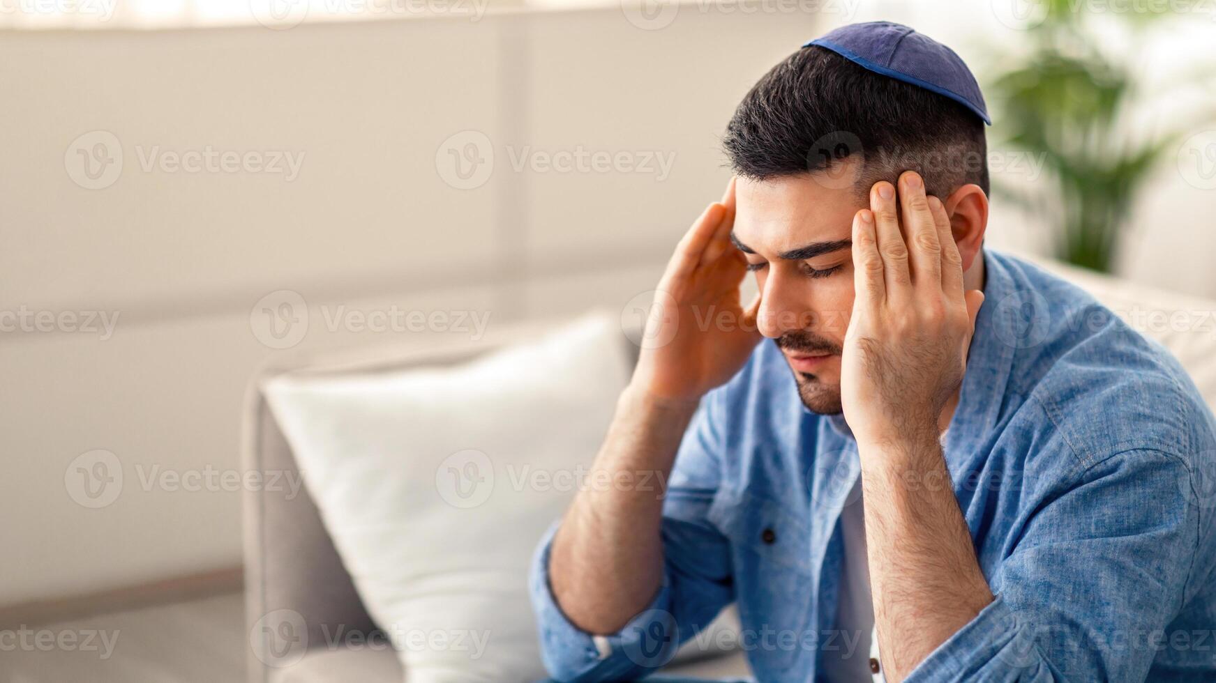 Sad tired young man touching and massaging his temples having headache migraine or depression, upset frustrated guy troubled with problem feeling stressed suffer from grief, sorrow concept photo