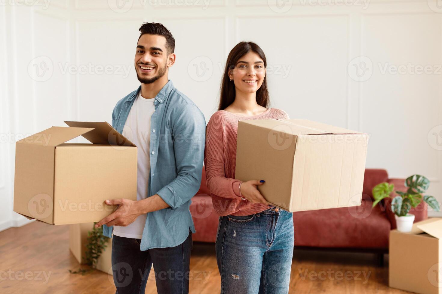 Happy Young Spouses Holding Cardboard Boxes For Moving, Relocating To New Apartment Standing At Home. Real Estate Rent, Mortgage And Ownership Concept. Family Preparing To Move House Packing Staff photo