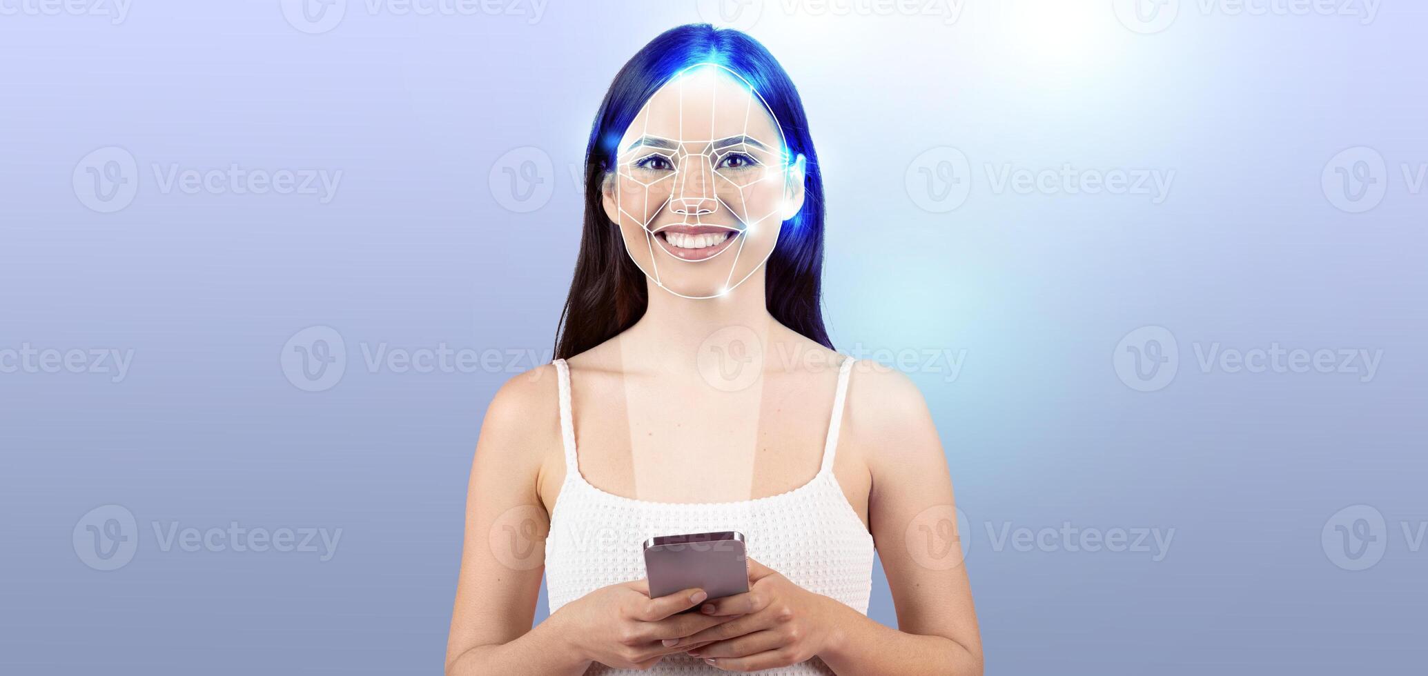 A woman smiles while holding a smartphone, showcasing advanced facial recognition technology. She appears engaged in a modern setting, highlighting the importance of digital identification. photo