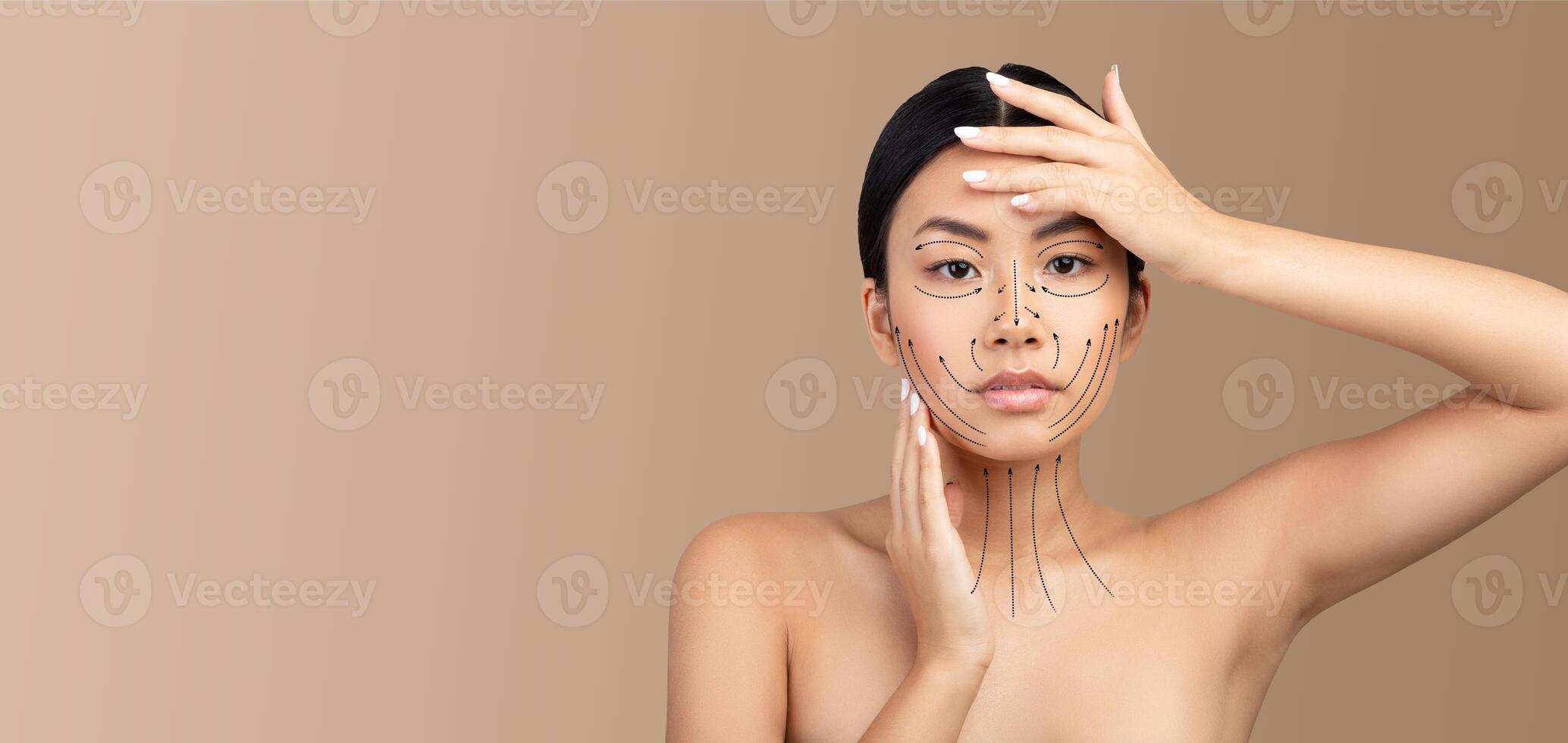 Asian woman is engaged in a skin care routine, gently applying facial techniques while showcasing contouring lines on her face. The background emphasizes her beauty and focus on pampering. photo