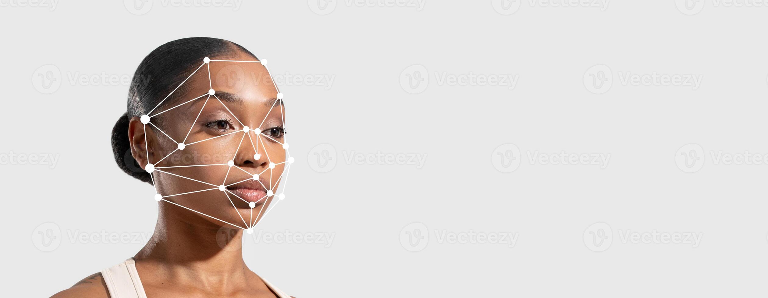 A person is demonstrating advanced facial recognition technology focused on facial features. The background is plain, emphasizing the technology's application for identification and security. photo