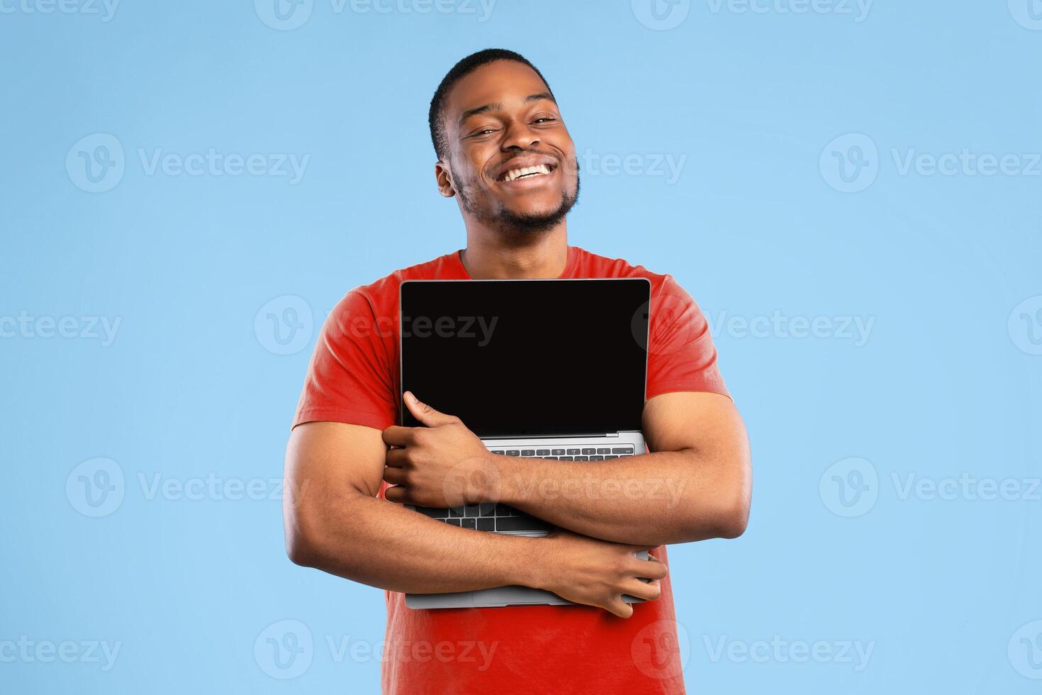Great Website. Happy African American Man Hugging Laptop With Empty Screen Posing Over Blue Studio Background, Smiling To Camera. I Love Computers Concept. Technology, People And Gadgets photo