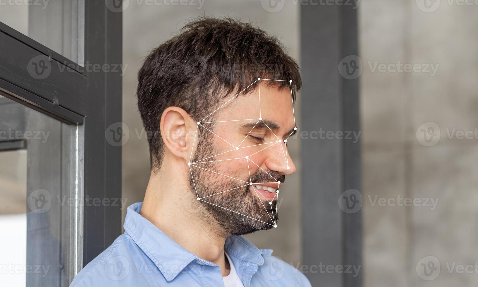 A man demonstrating facial recognition technology. The facial features are highlighted with geometric lines, showcasing the identification process in a modern environment. photo