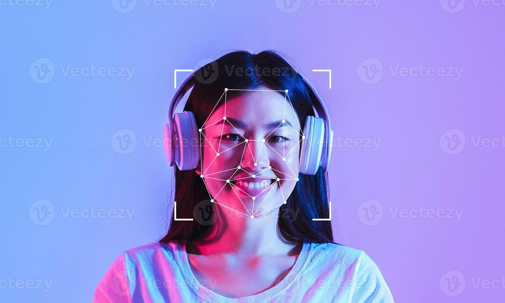A woman wearing headphones smiles as a facial recognition overlay appears on her face. Bright blue and purple colors create a modern and tech-focused atmosphere. photo