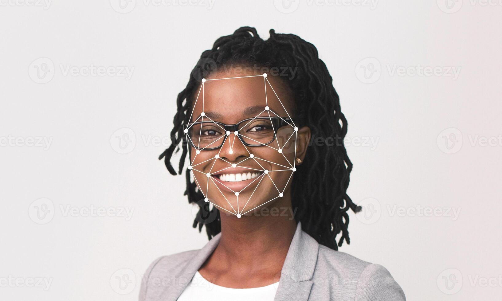 A smiling woman with glasses and dreadlocks is showcased against a light background, highlighting facial recognition technology. The focus is on her joyful expression and the technology overlay. photo