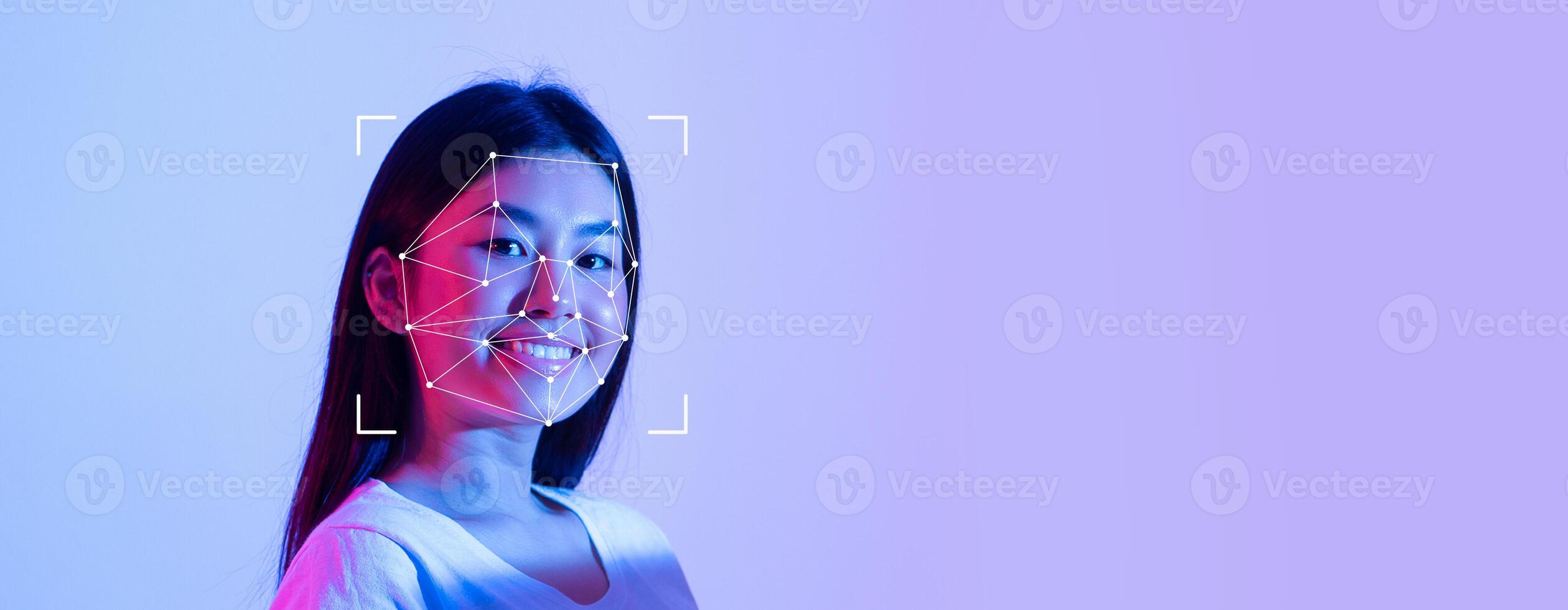 A smiling person is captured with facial recognition technology, showcasing a digital overlay that highlights facial features. The bright, colored background enhances the high-tech atmosphere. photo