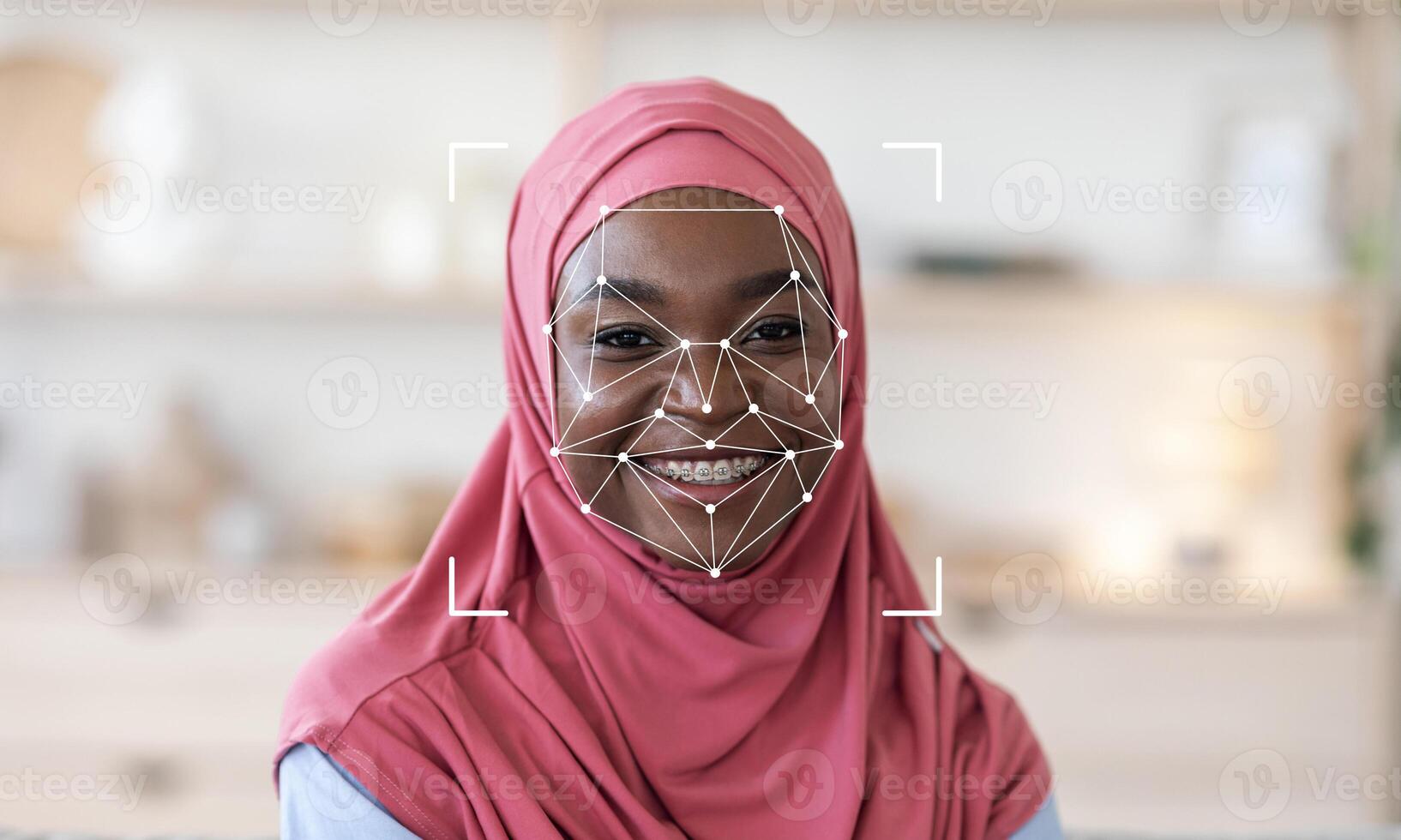 A woman wearing a hijab smiles as facial recognition technology analyzes her features. This scene represents the advancement of identification technology in modern society. photo