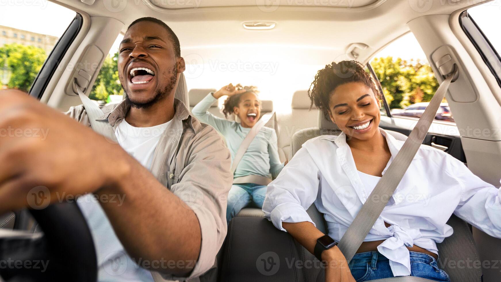 Joyful African American Family Riding New Car Singing And Having Fun During Summer Road Trip. Parents And Daughter Traveling By Auto On Weekend. Transportation. Selective Focus photo