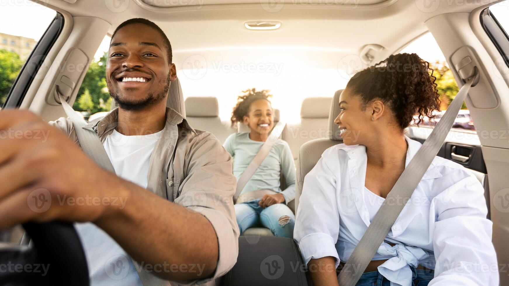 Happy African American Family Driving New Automobile Having Ride In City, Enjoying Road Trip. Parents And Daughter Spending Vacation Traveling By Car. Auto Purchase And Rent. Selective Focus photo