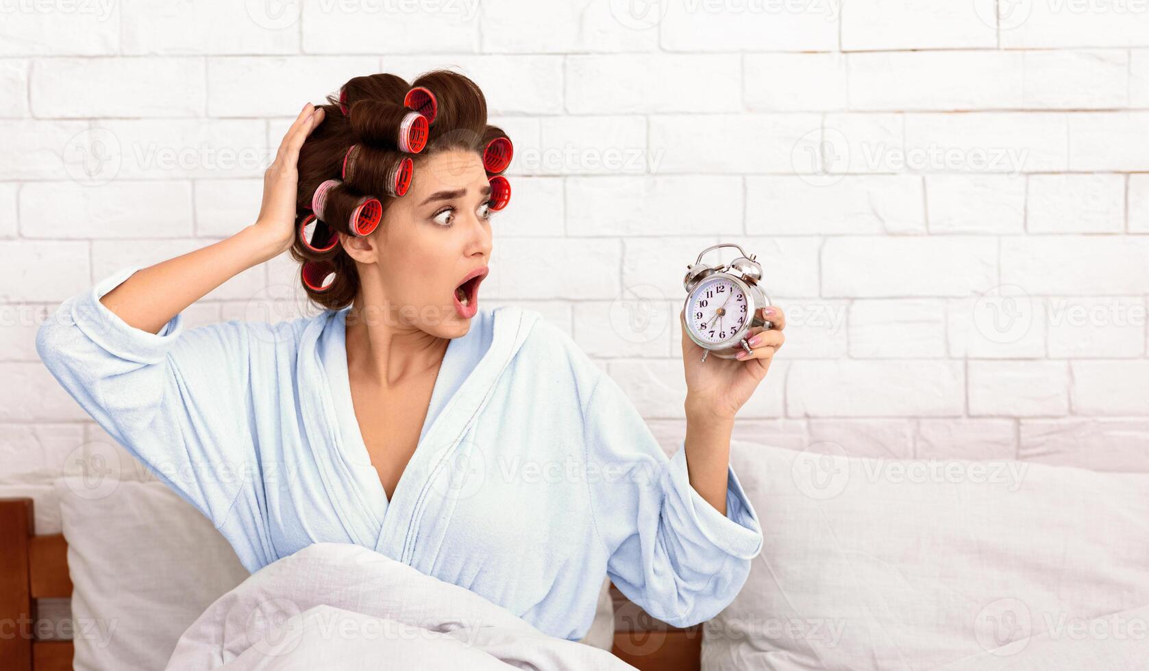 Being Late. Shocked Girl Looking At Alarm Clock Sitting In Bedroom At Home. Free Space photo