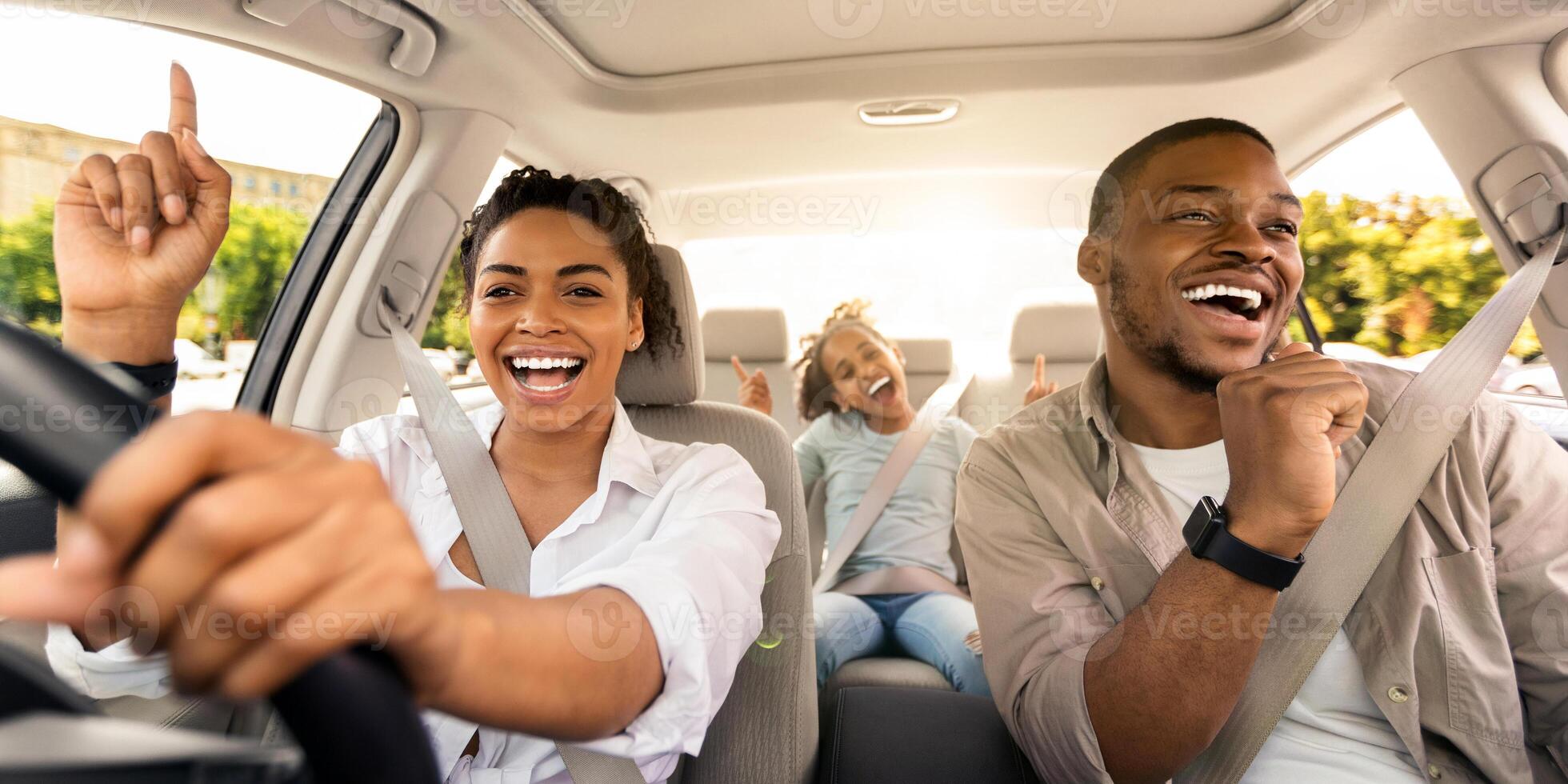 Cheerful Black Family Singing Riding New Car Having Fun Enjoying Road Trip On Vacation. Parents And Daughter Traveling By Automobile In Summer. Selective Focus photo