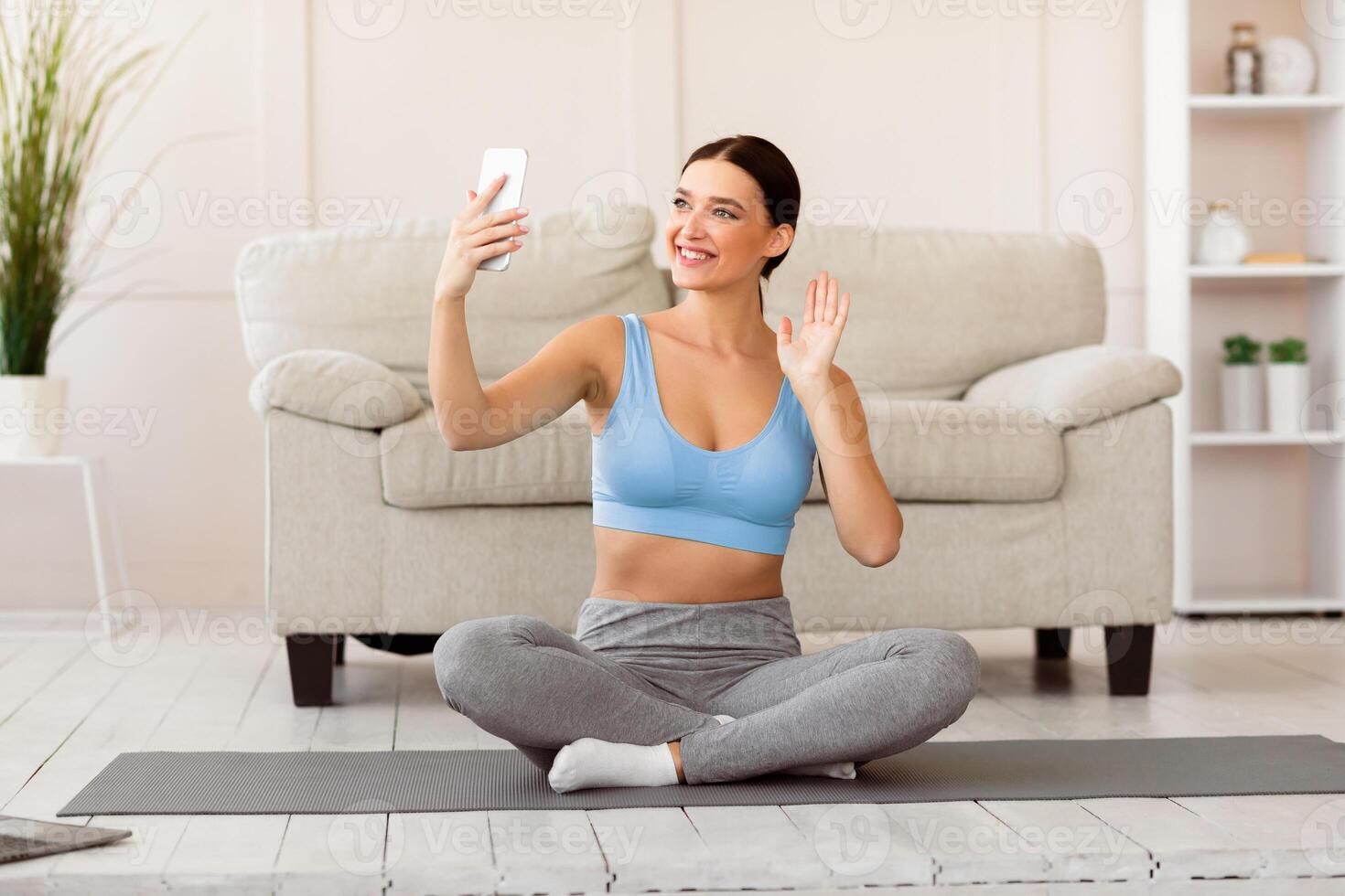 Online Fitness Training. Fit Woman Making Call Holding Smatphone Exercising At Home photo