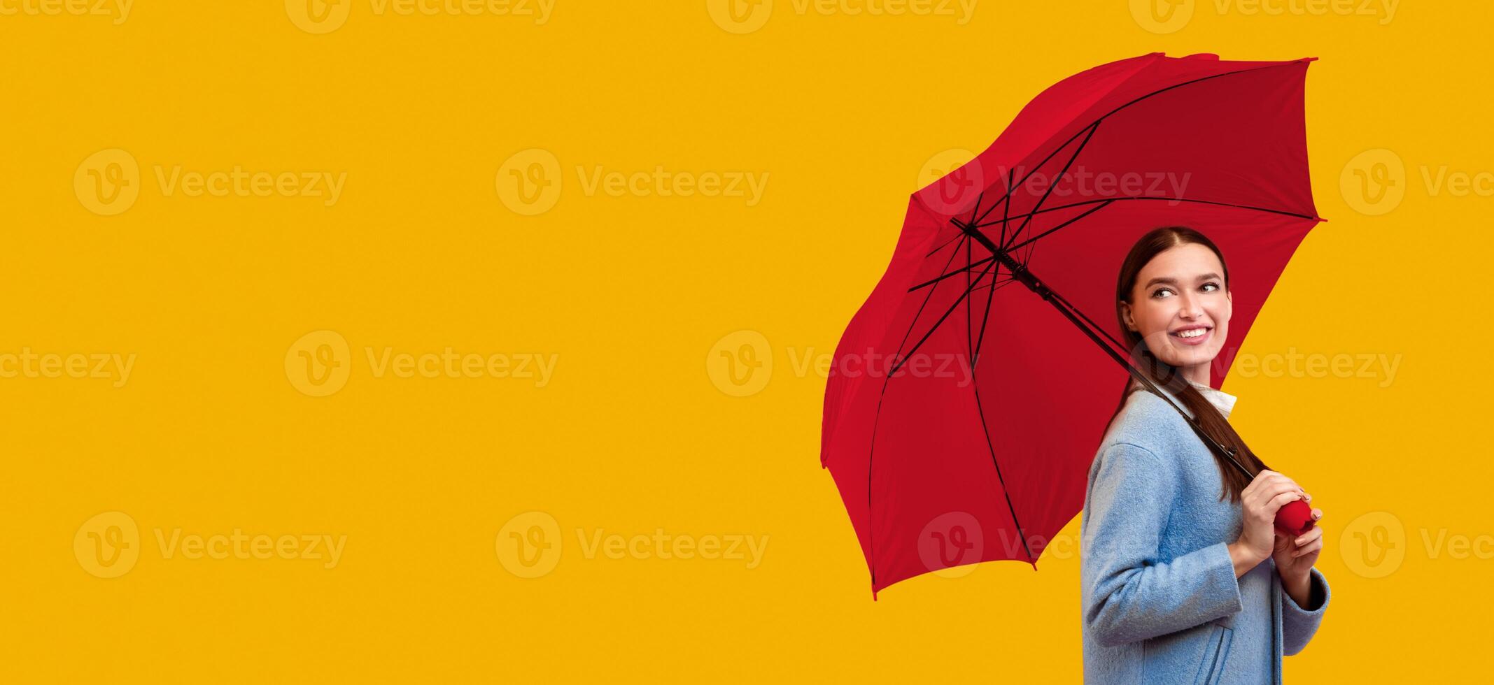 Fancy Girl. Portrait of fashionable girl carrying yellow parasol and looking back at copy space for you ad, logo or text photo