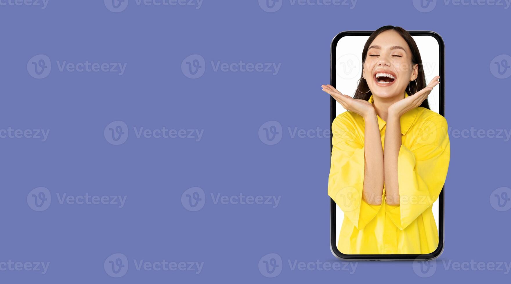 A person in a bright yellow outfit smiles widely while holding a smartphone. They express enthusiasm and happiness, embodying the joy of social media and communication technology. photo