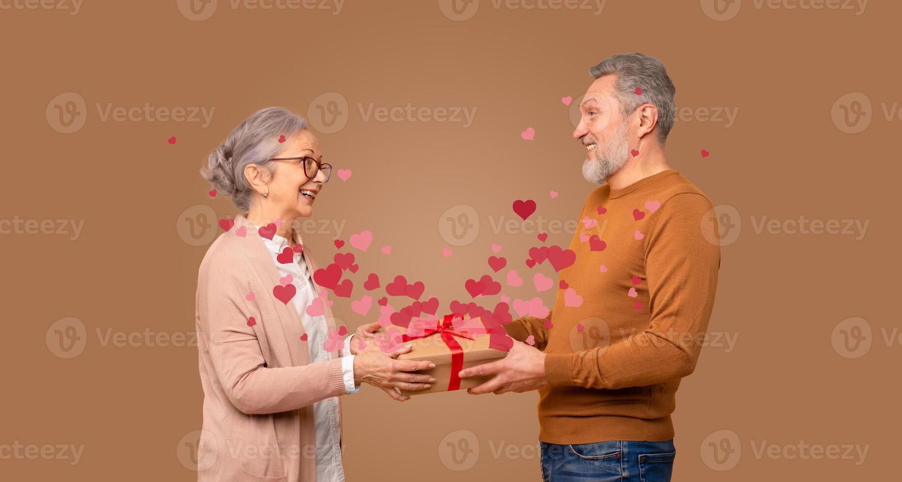 A loving couple shares a heartfelt moment as they exchange gifts, surrounded by floating hearts. This scene captures the essence of affection and joy on a special day dedicated to love. photo