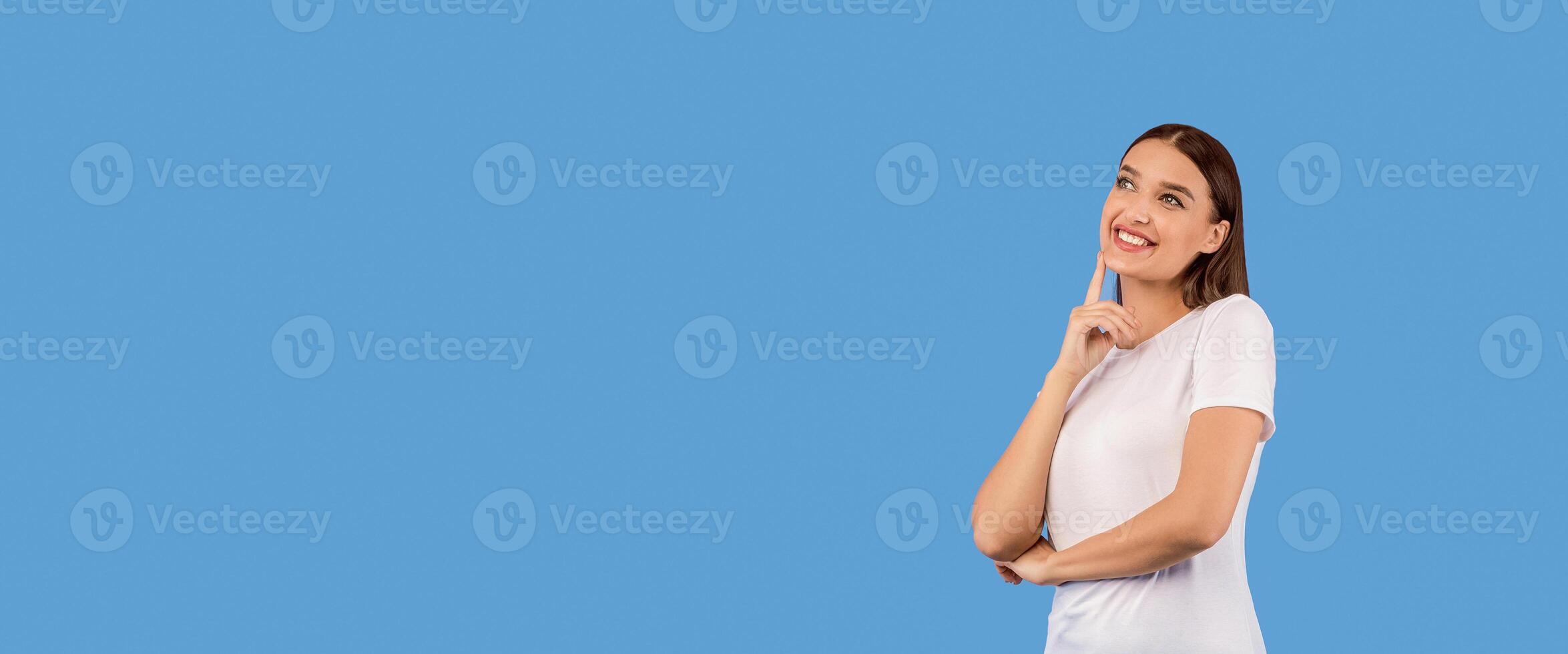 Making Decision. Full length portrait of smiling girl looking up, holding hand on chin, isolated over purple wall, copyspace photo