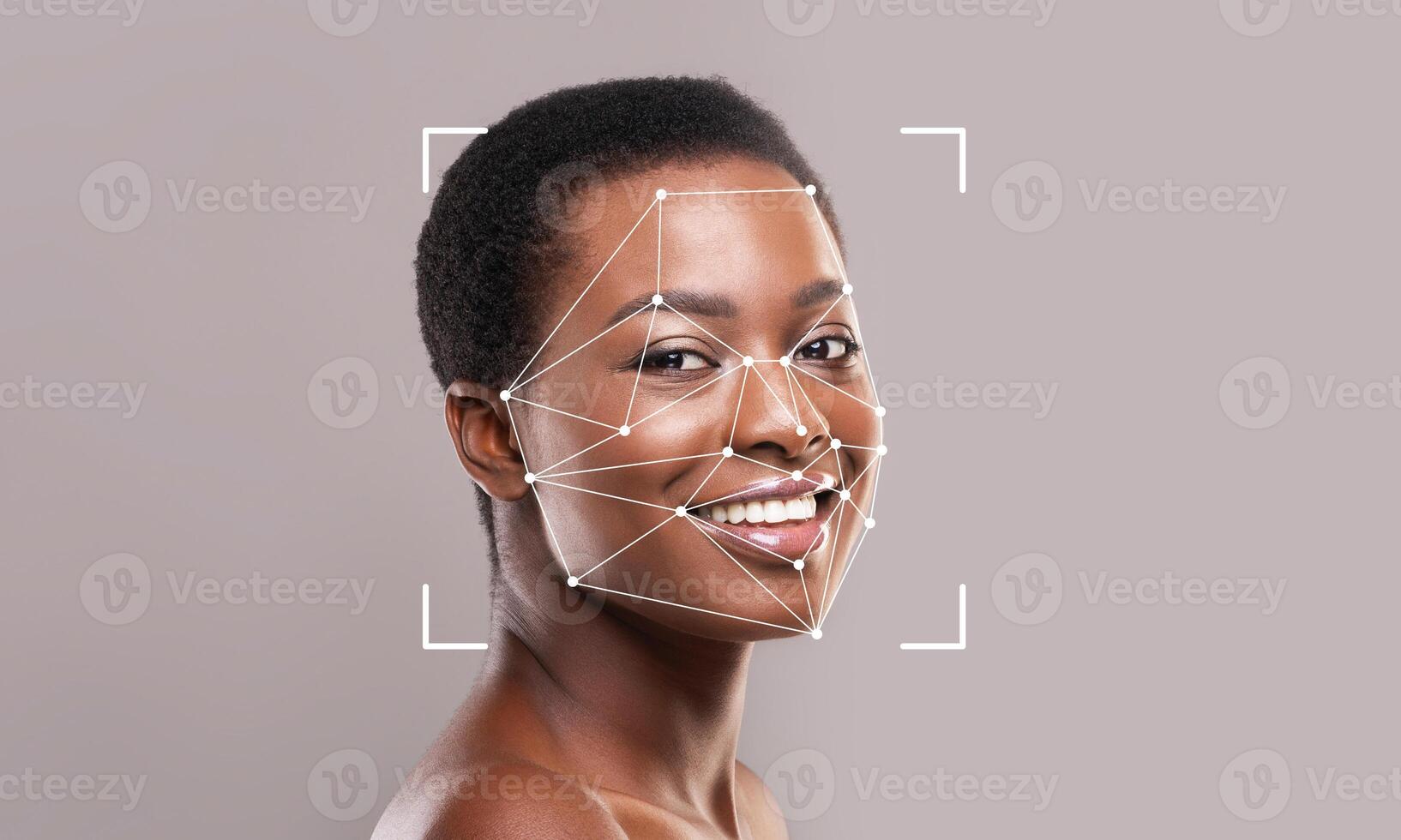 A woman with a bright smile poses in front of a gray background. Facial recognition technology overlays geometric lines and points on her face, illustrating identification capabilities. photo