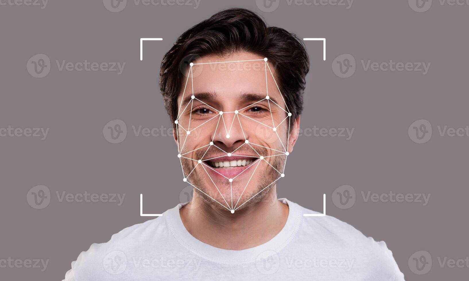 A young man is smiling while being analyzed by facial recognition technology. The geometric overlay highlights key facial features, illustrating advanced identification capabilities. photo