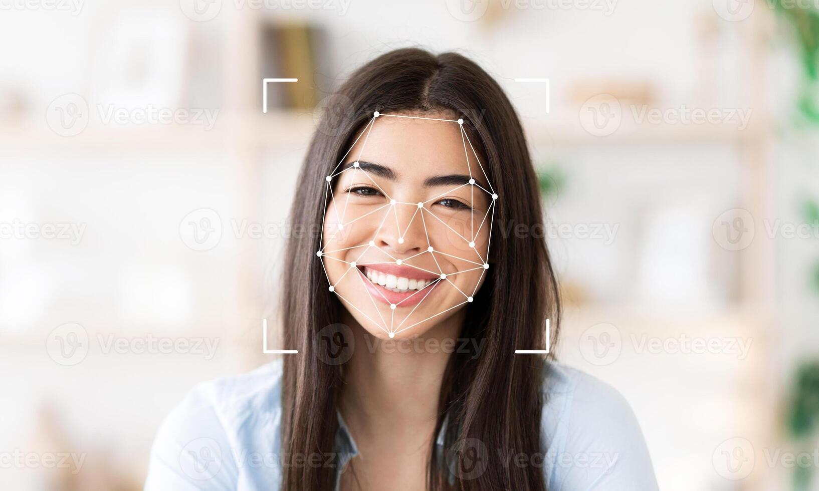 A smiling woman with long dark hair is featured in a well-lit indoor space. Facial recognition technology is visible, highlighting key facial features. photo