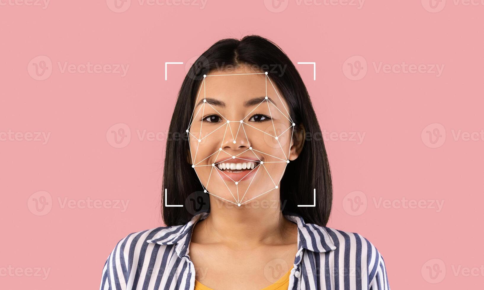 A young woman smiles while facial recognition technology identifies her features. This highlights advancements in identification methods and their implications in various fields. photo