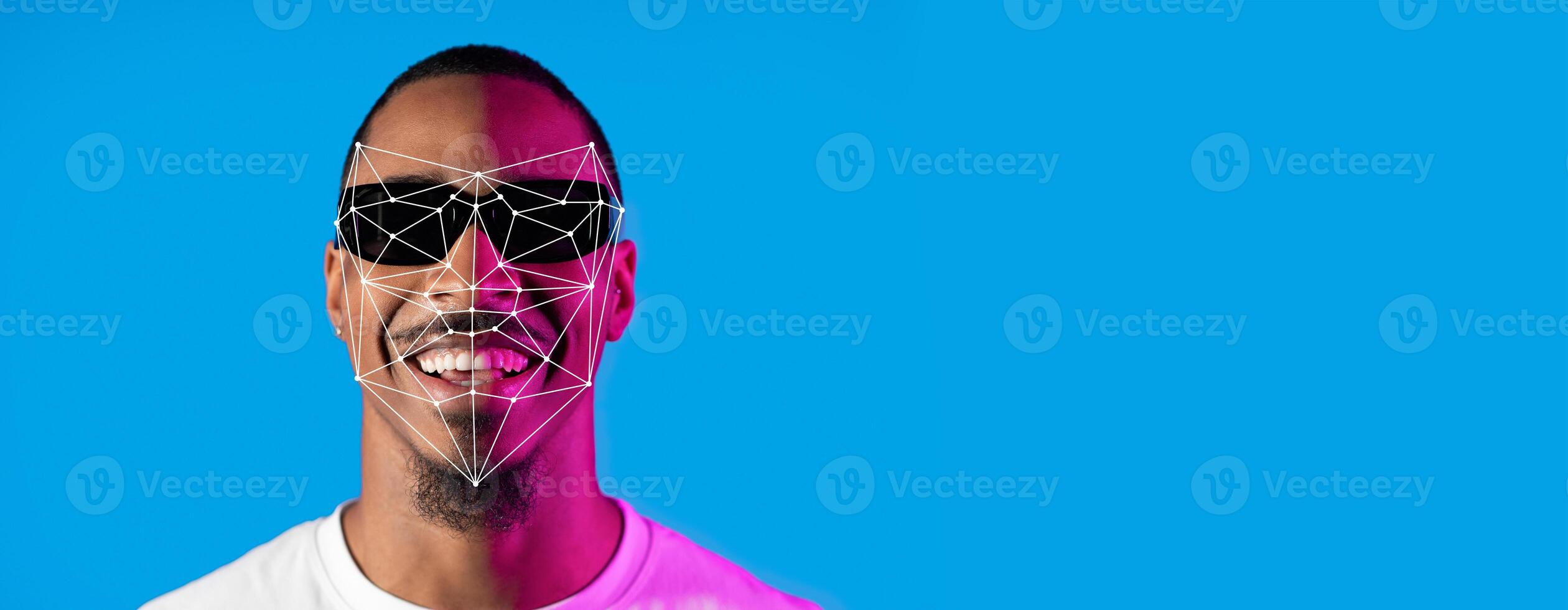 A person wearing sunglasses smiles confidently against a bright blue background. Facial recognition lines and points overlay the face, showcasing advanced identification technology in detail. photo