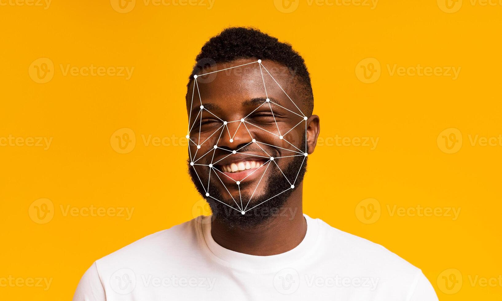 A young man is smiling against a bright yellow background, showcasing facial recognition technology overlay on his features. The image highlights advancements in identification and data processing. photo
