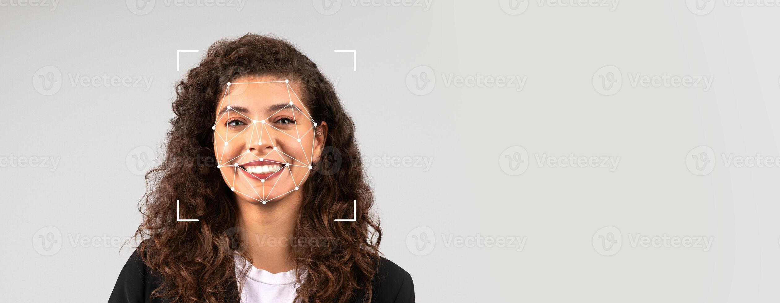 A woman stands against a blank background, smiling confidently. photo