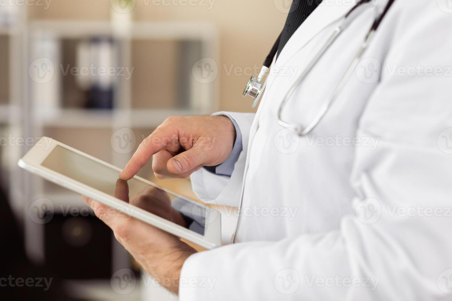 Telemedicine And Technology Concept. Side view close up of unrecognizable doctor using tablet at hospital photo