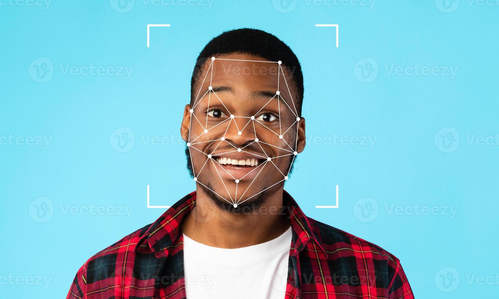 A young man smiles widely as facial recognition technology highlights his features against a blue background. His expression conveys confidence in this modern technology setting. photo