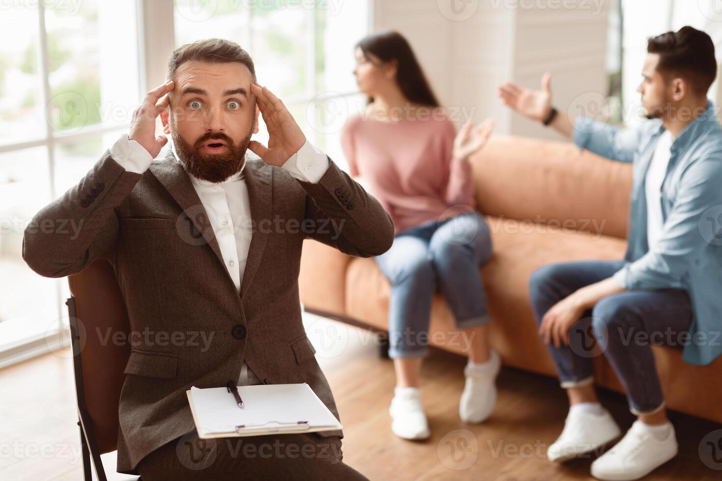 Couple Quarreling During Therapy Session Sitting On Couch, Shocked Psychotherapist Can't Stop Their Arguing, Counselor Man Grabbing Touching Head In Surprise, Failed To Help Save Marriage photo