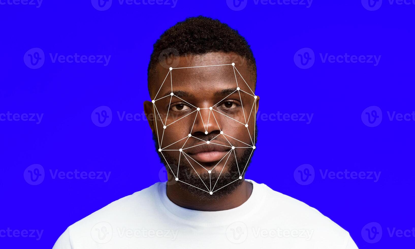 A man stands against a bright blue background, while a facial recognition technology overlays map points on his face. The display showcases advancements in identification systems and methods. photo