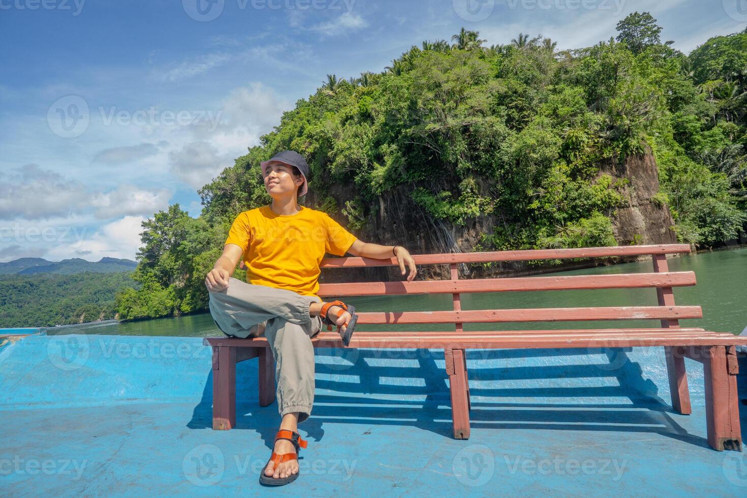 Serene Lake View Man Relaxing on a Boat in Lush Tropical Landscape photo