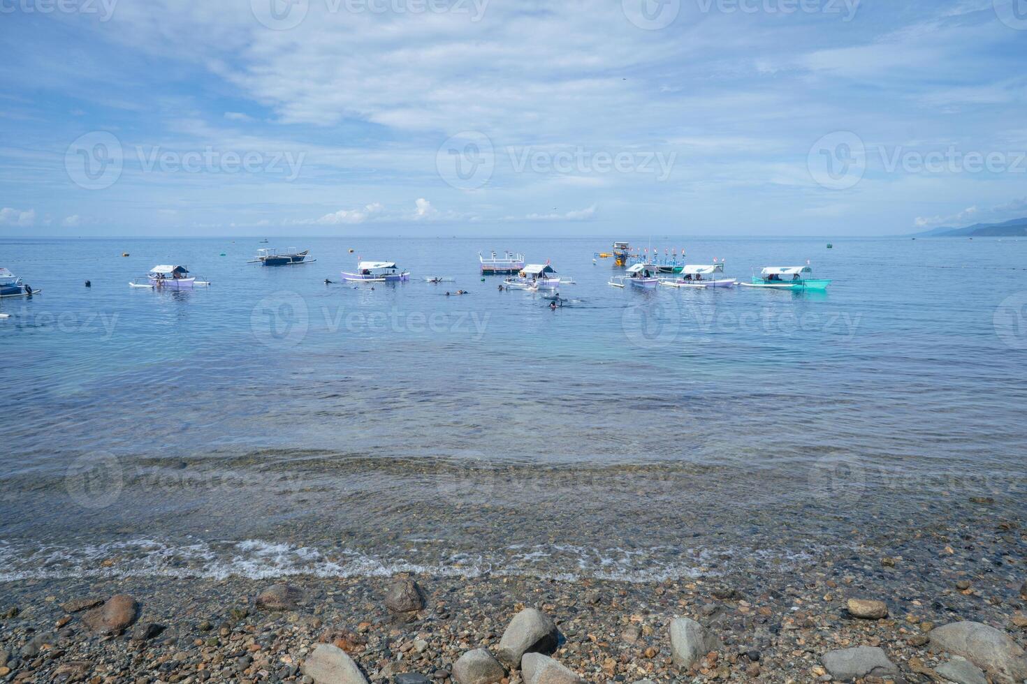 Breathtaking Coastal Scenery with Anchored Boats and Peaceful Waves photo