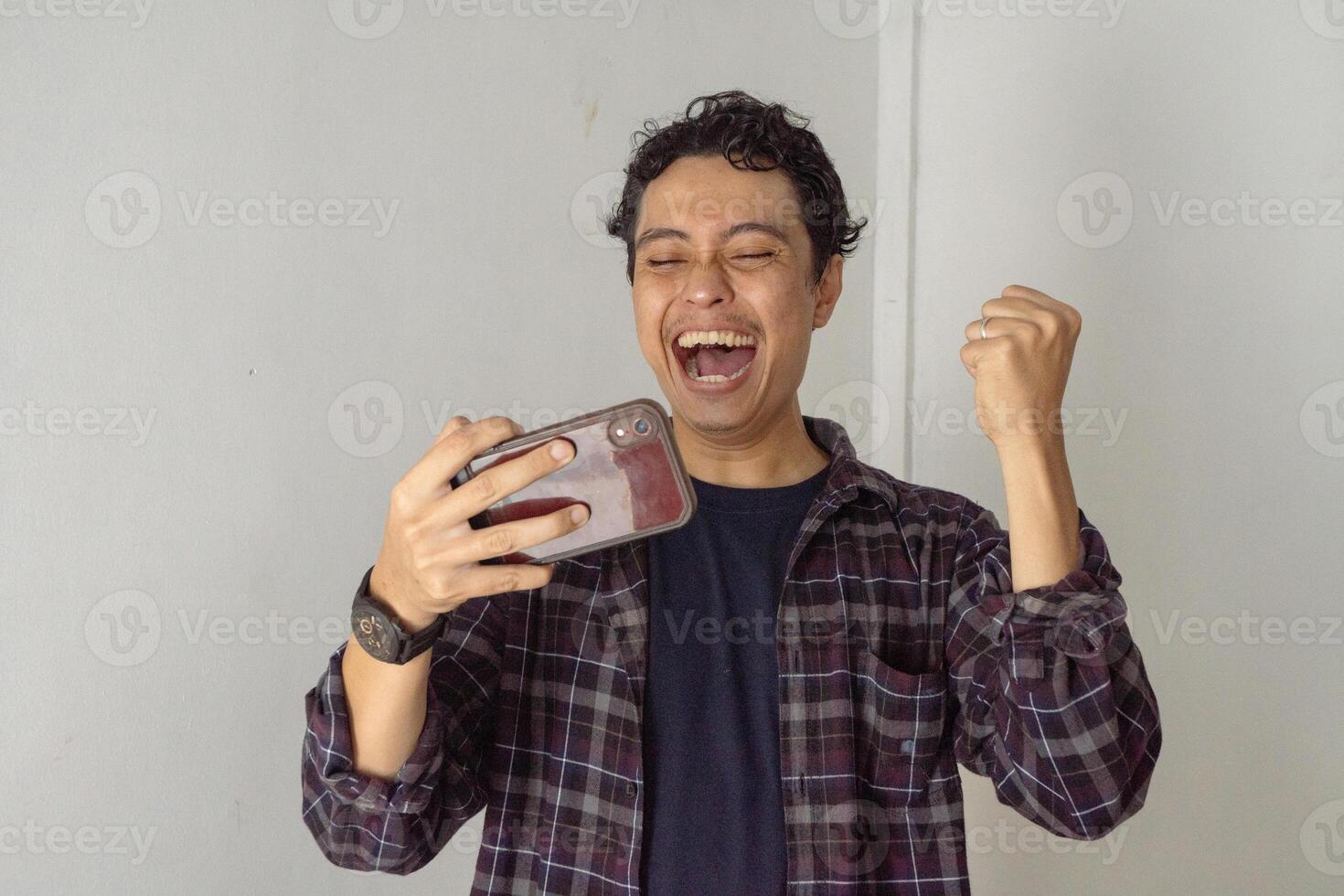 Excited Man Celebrating on His Smartphone photo