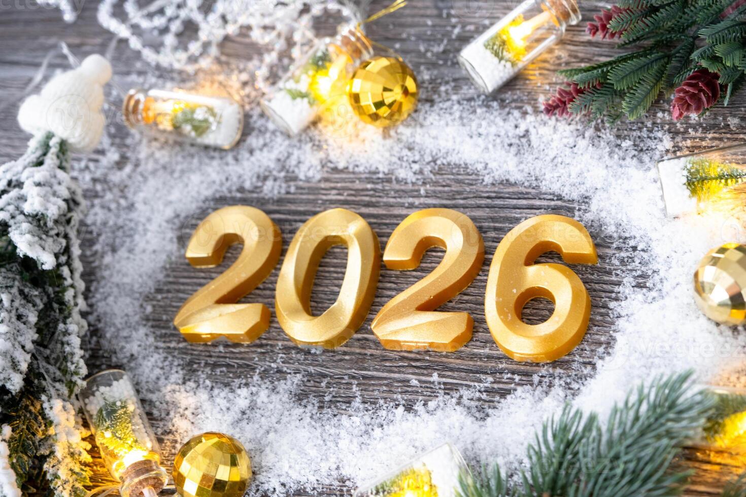 Happy New Year numbers 2026 on cozy festive grey wooden background with Christmas tree, snow, lights of garlands. Greetings, postcard. Calendar, cover photo
