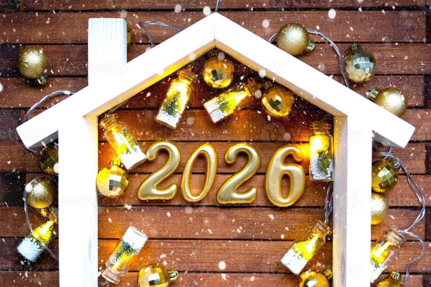 Golden figures number 2026 and tiny home background of cozy windows of a house with warm light with festive decor of stars,snow and garlands. Greeting card, Happy New Year, cozy home photo