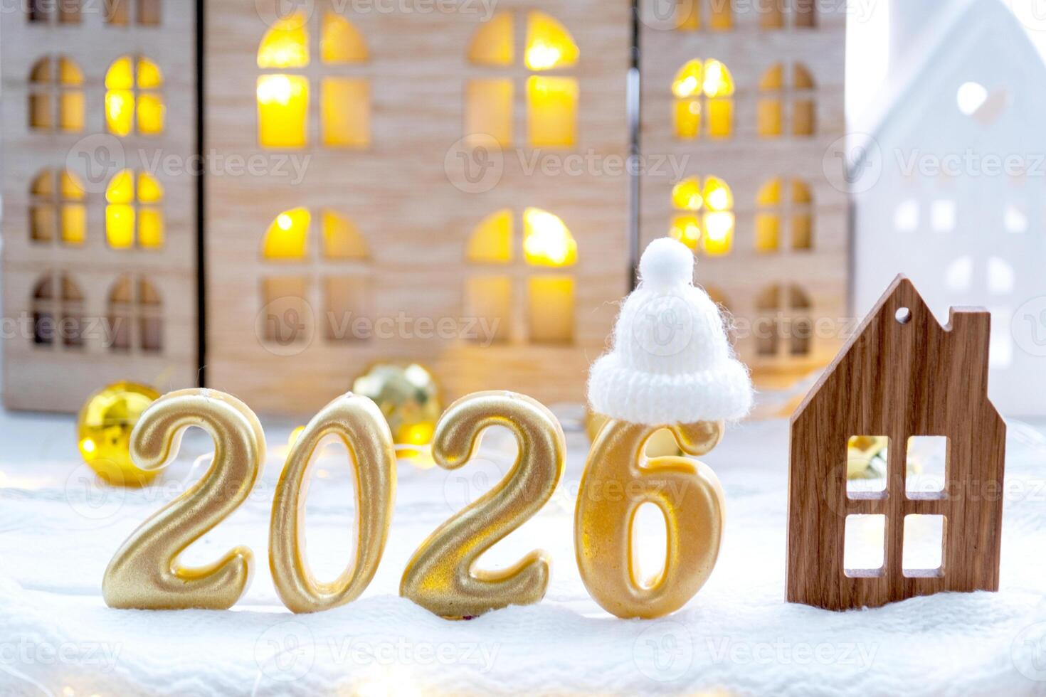 Golden figures number 2026 and tiny home on background of cozy windows of a house with warm light with festive decor of stars,snow and garlands. Greeting card, Happy New Year, cozy photo