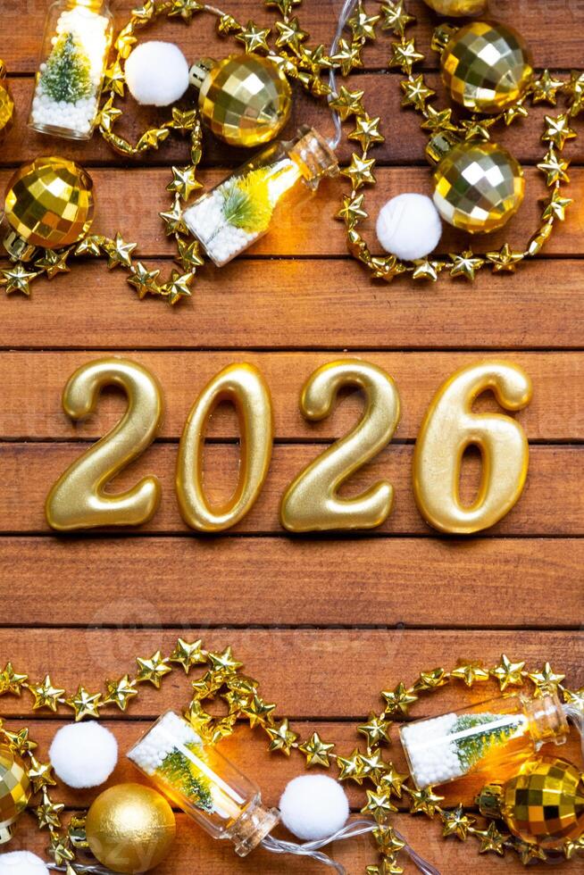 Happy New Year wooden numbers 2026 festive brown wooden background with sequins, snow, lights of garlands. Greetings, postcard. Calendar, cover photo