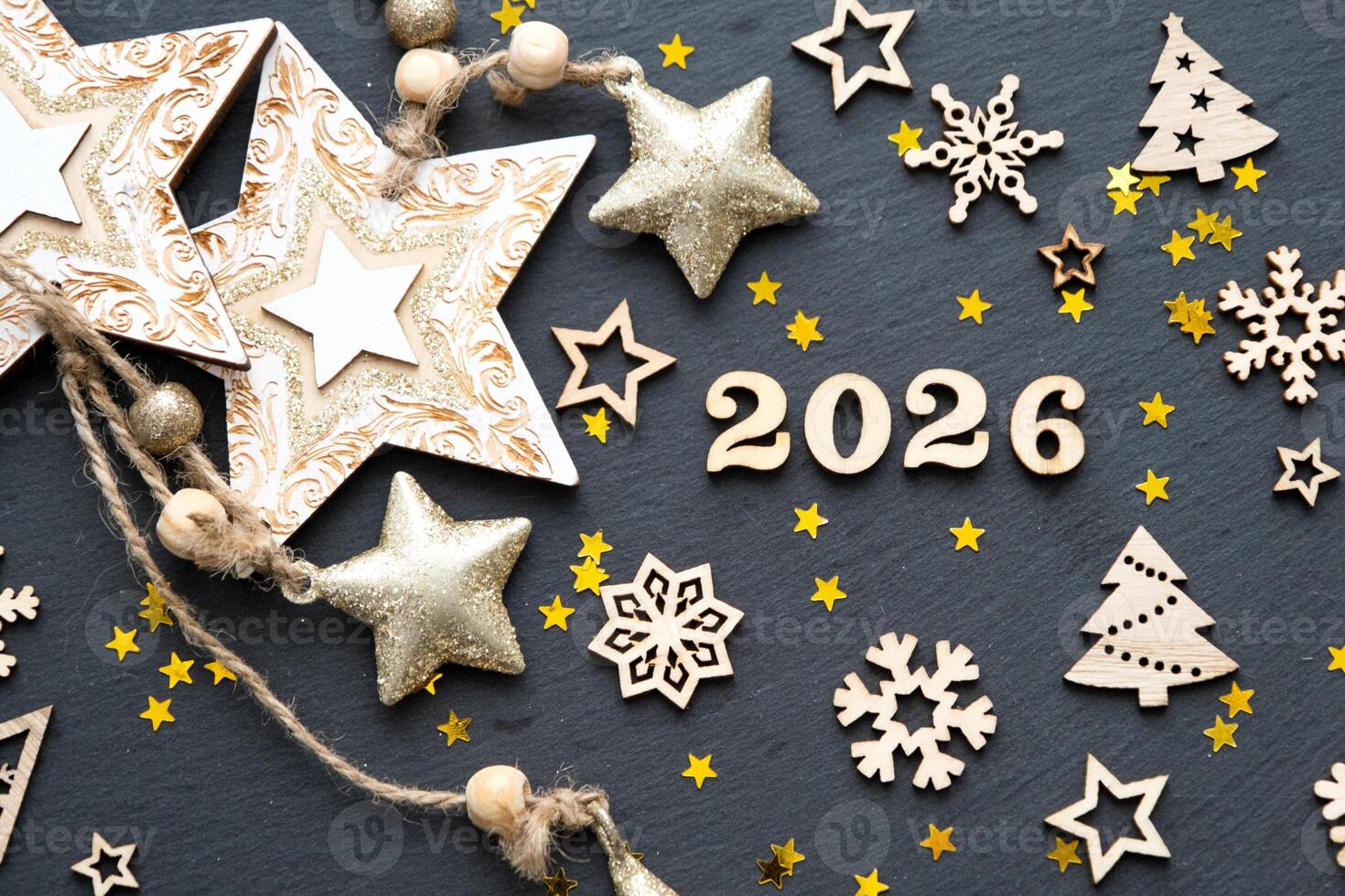 Happy New Year-wooden letters and numbers 2026 on festive black background with sequins, stars, snow. Greetings, postcard. Calendar, cover photo