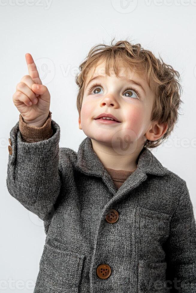 A young boy in a coat pointing up photo