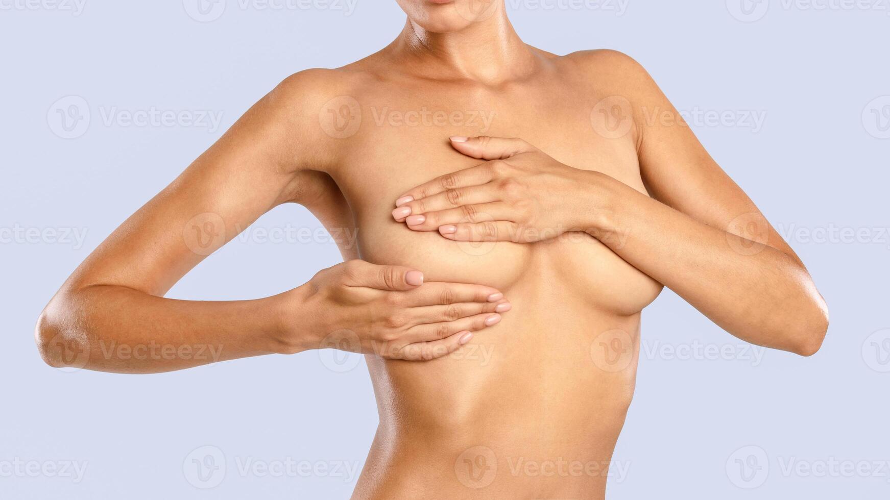 Breast Cancer Awareness Month In October, Self Screening. Young woman examining her bust standing isolated on blue studio background, closeup. Healthcare, Breast Self-Exam BSE Test Concept photo