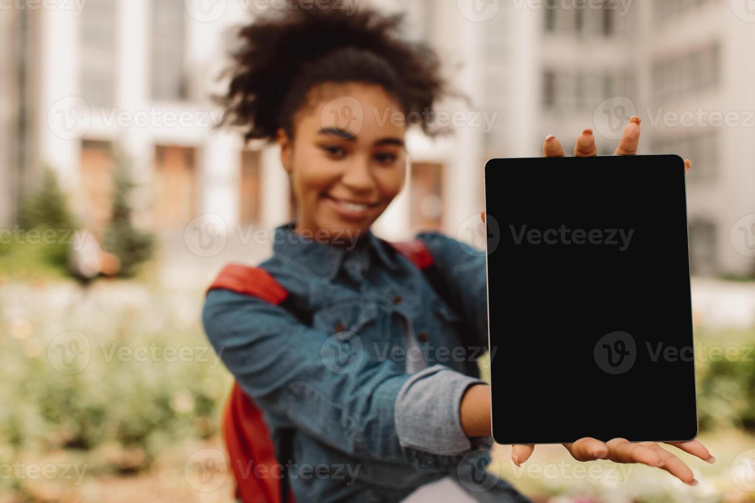E-Learning. African American Student Girl Showing Digital Tablet With Blank Screen Advertising Educational Website Smiling To Camera Standing Outdoors. Mockup, Selective Focus On Computer photo