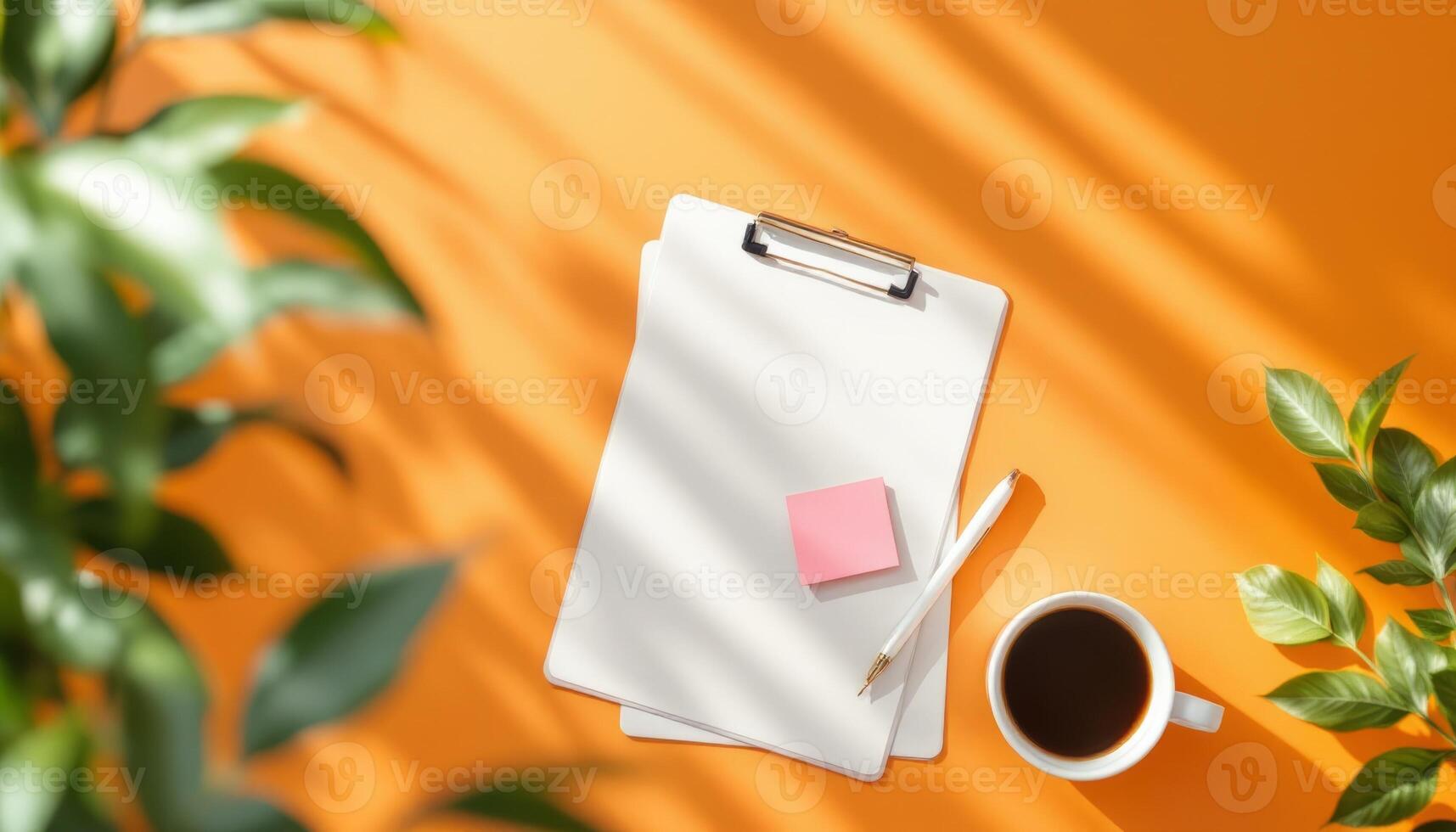 Bright Workspace Setup with Clipboard and Coffee on Orange Backdrop photo