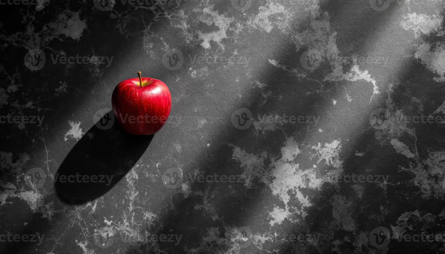 Crimson Apple on a Textured Dark Surface with Dynamic Light and Shadow Play photo