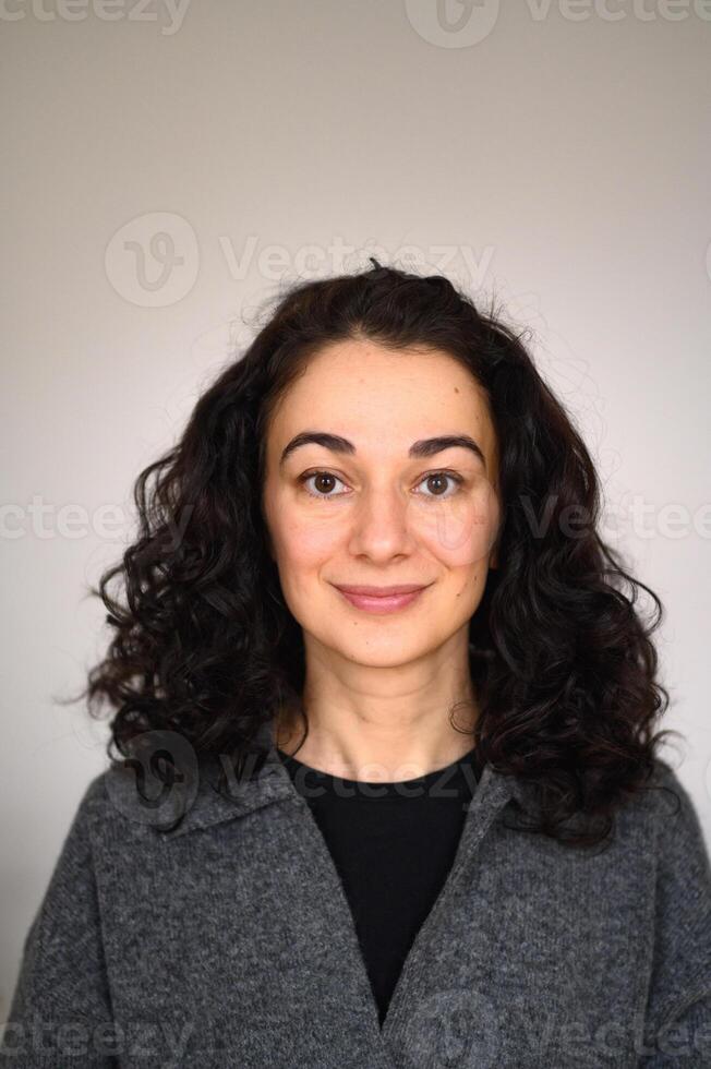 An isolated woman's portrait looking straight forward and smiling photo