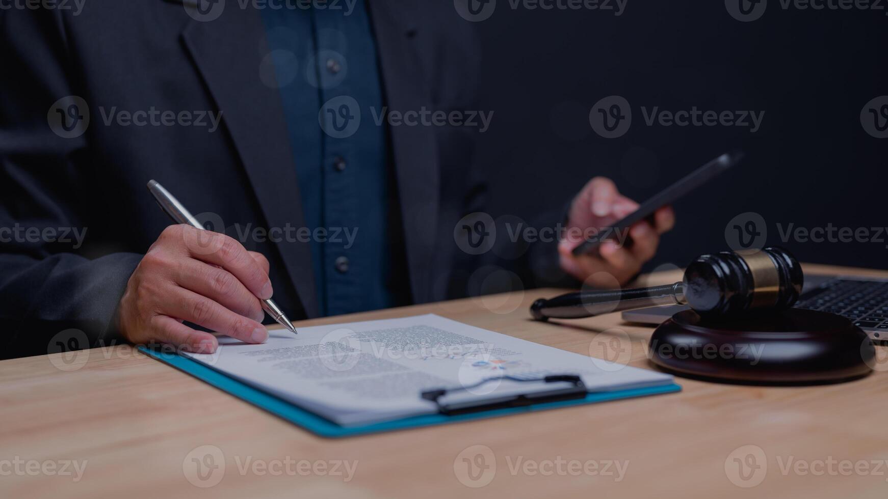Image depicts lawyers desk with gavel, legal documents, and smartphone, emphasizing intersection of traditional law and modern technology in legal practice photo