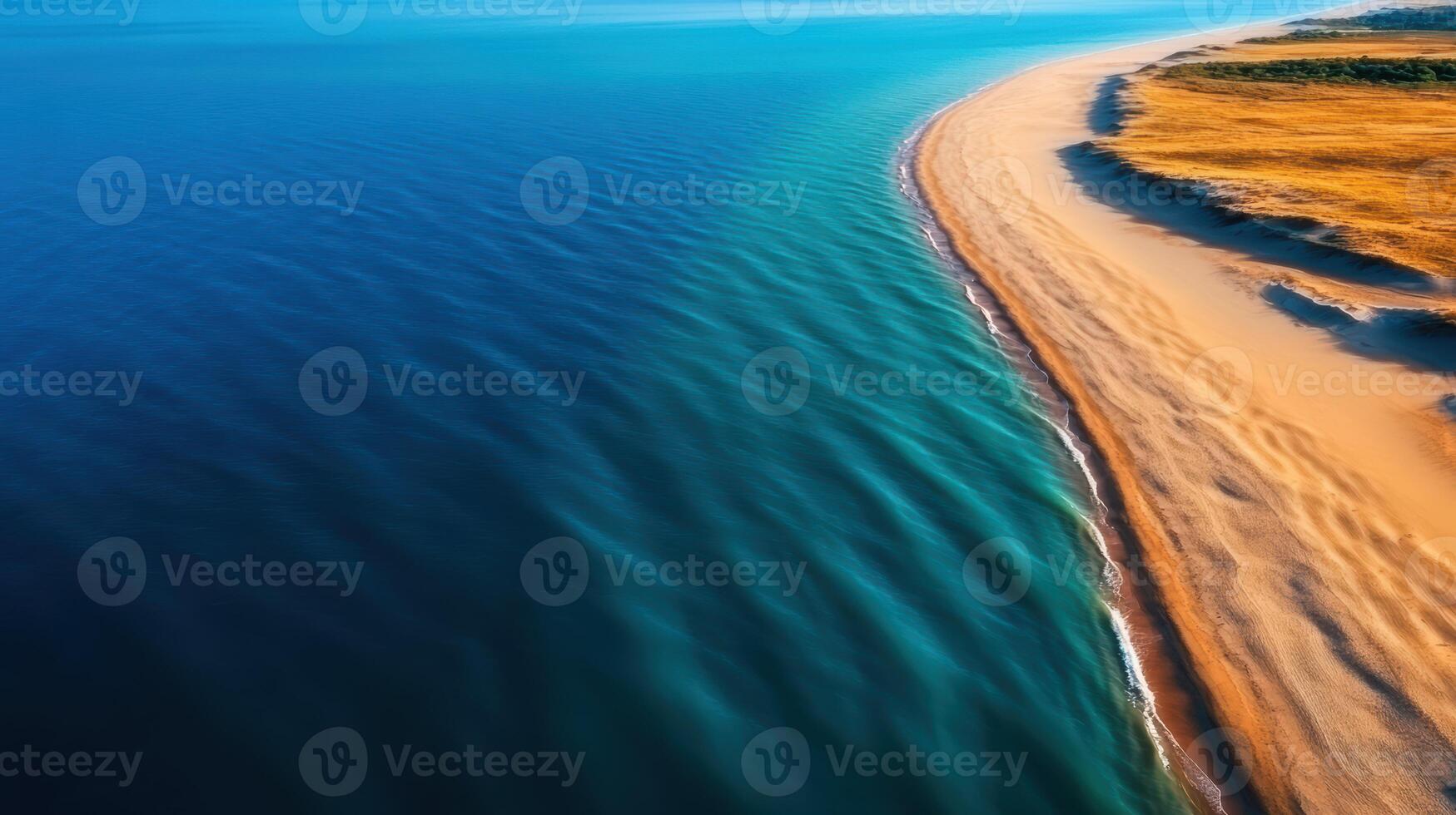 A beautiful blue ocean with a sandy beach. The water is calm and the sky is clear. The beach is a perfect place to relax and enjoy the view photo